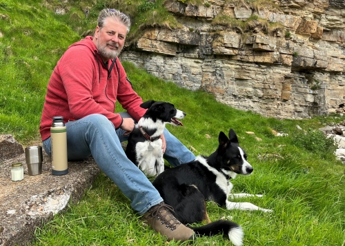 Robert James sitting outside with two dogs